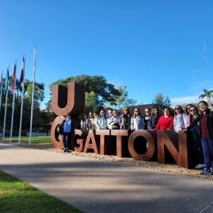 Group of people stand next to UQ Gatton sign