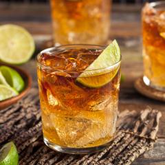 A glass of rum with a slice of lime